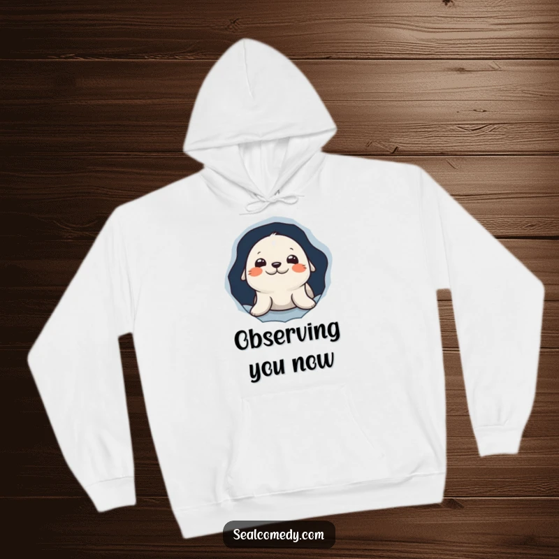Funny hoodie with a curious seal character peeking out from a hole in the ice, offering a cozy and humorous look.