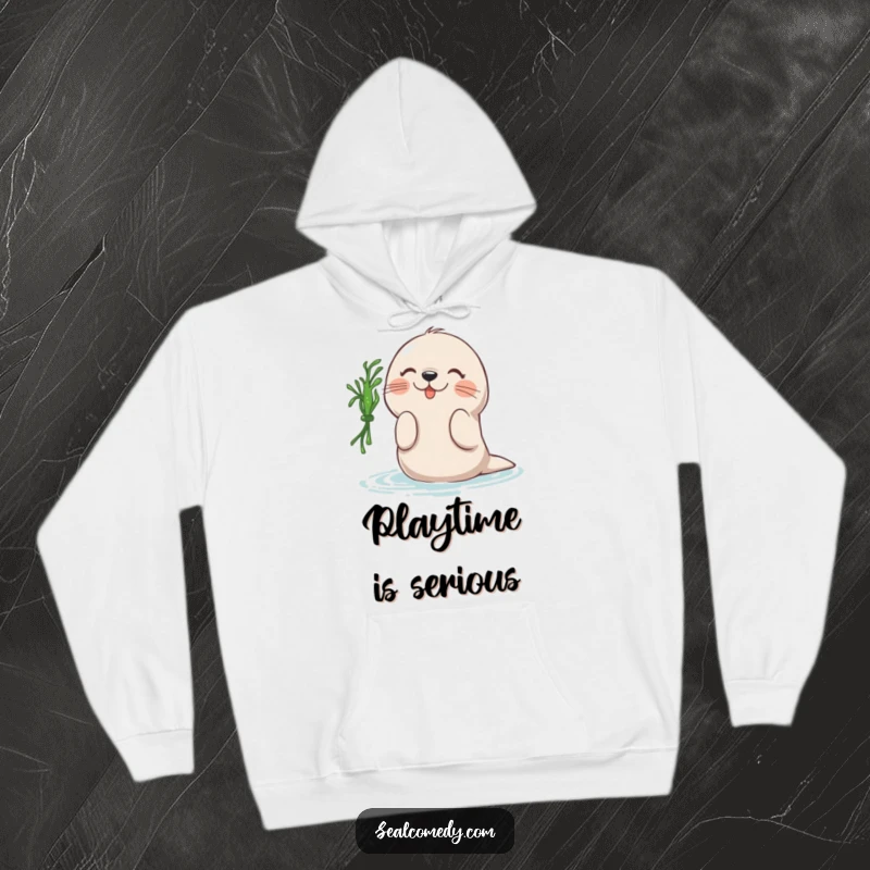 Funny hooded sweatshirt featuring a seal joyfully batting at a floating piece of seaweed, a humorous and cozy design for sea lovers.