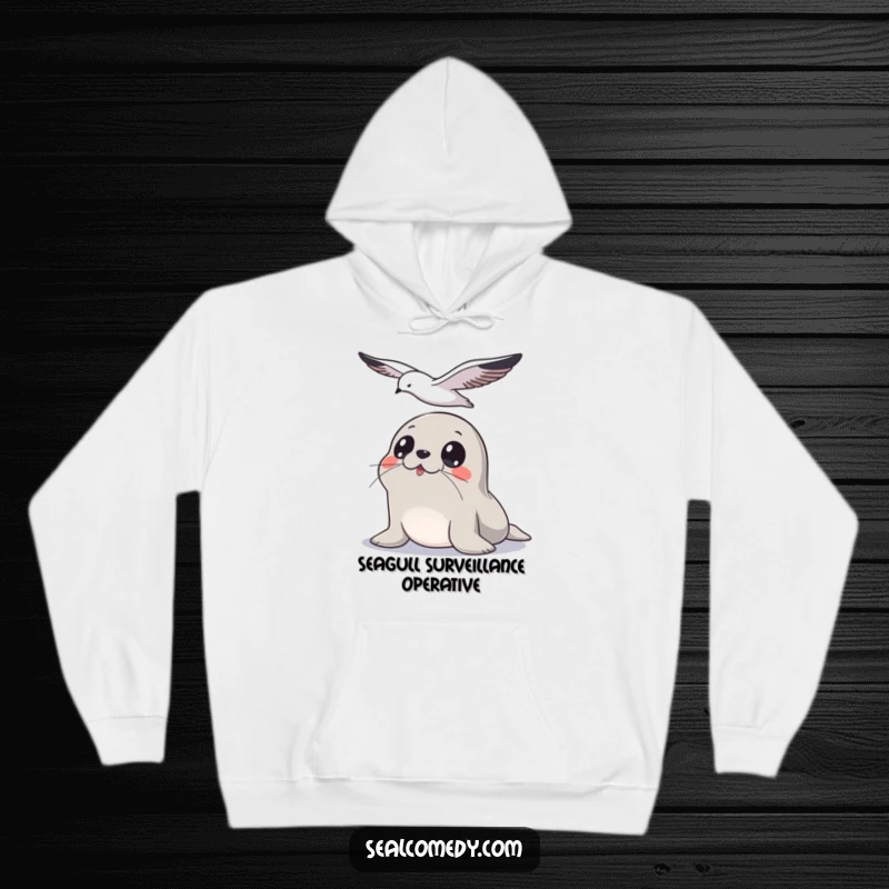 Funny Seal Hoodie: An alert seal with big eyes tracks a seagull flying overhead, embodying humorous watchfulness.