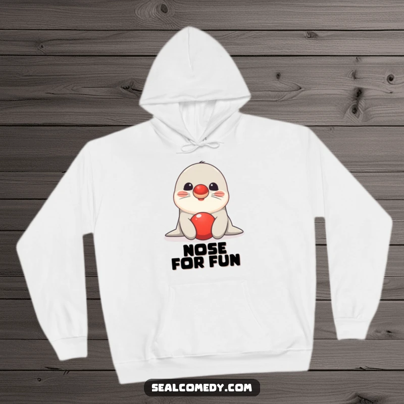 Funny seal hoodie showing a happy creature balancing a red ball on its nose, radiating charm and impressive talent.