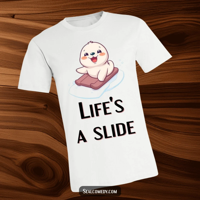 Funny seal pup joyfully sliding down a snowy slope, a smile on its face, printed on a comfortable t-shirt.