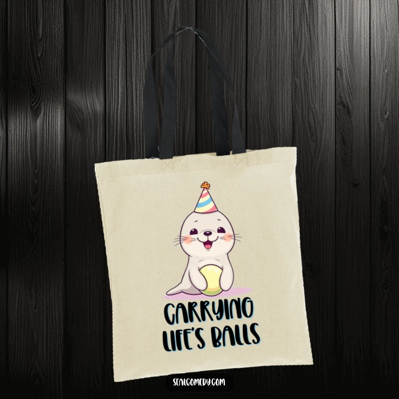 Funny seal pup in a party hat, confidently balancing a ball, featured on a durable tote bag for a touch of playful charm.